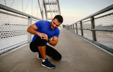 Sportsman holding his injured leg. Sport, recreation concept