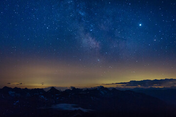 The Milky Way in the night sky over the Austrian Alps. View from the way to Grossglockner rock summit, Kals am Grossglockner, Austria