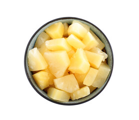 Pieces of delicious canned pineapple in bowl on white background, top view