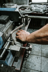 Close up shot of manual worker hands. Factory for industrial production of hydraulic hoses.