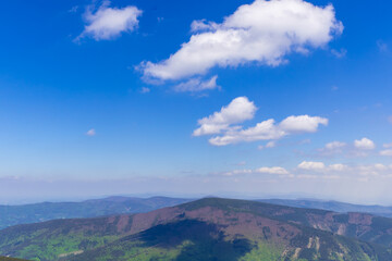 Mountainous landscape and views of the hills during a sunny day with clouds in the sky.