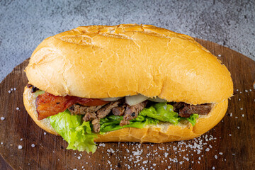 Big homemade sandwich with beef, lettuce, tomato, onion and cheese. Brazilian style