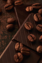 brown coffee grains lies on chocolate at the table.