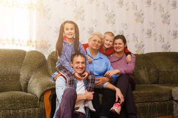 Grown up adult smiling grandchildren embraces elderly grandmother glad to see missing her, visit of...