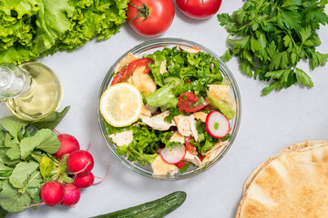 Mediterranean pita salad that includes lettuce, tomatoes, cucumbers, radishes and pieces of pita bread