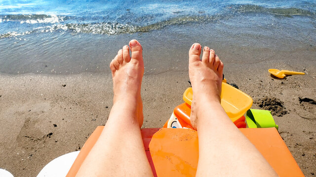 POV view on feet lying and relaxing on sunbed at sea beach