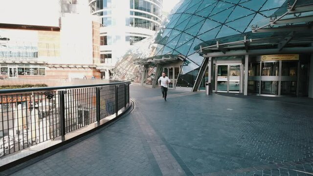 Young man runs. Handsome guy in hurry to meeting. Slow motion