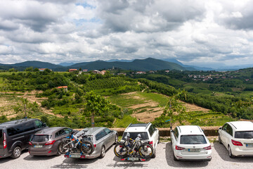 Naklejka premium Tourists in cars stopped to rest on top of a mountain against a blue sky with clouds