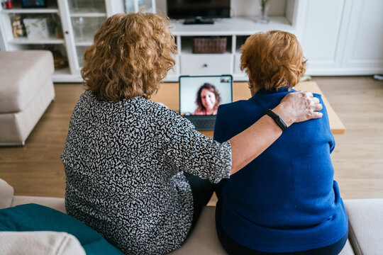 Women having video conversation on laptop at home