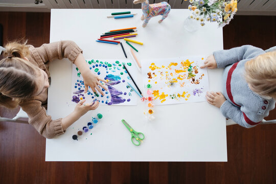 Preschool brother and sister painting together at home