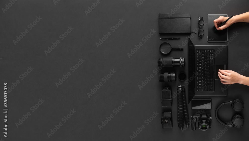 Fototapete designer or photography retoucher hands using graphic tablet on minimal black desk with room for tex