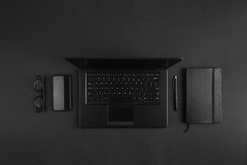 Minimal flat lay on modern businessman black desk with laptop - Powered by Adobe