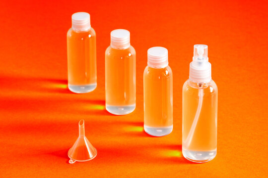 several clear bottles with hydrochloric gel along with a funnel to fill serves to disinfect covid-19's hands top view