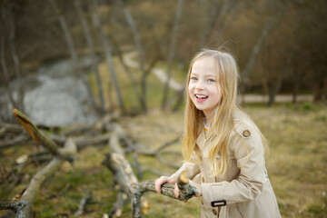 Cute young girl having fun on beautiful spring day. Active family leisure with kids. Family fun outdoors.