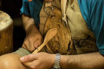 Crop carpenter carving hole in wood with chisel