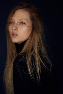 Beautiful young lady looking away against black background