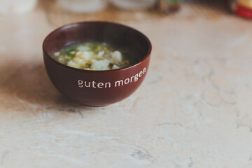 green soup with egg on the table in a dark plate