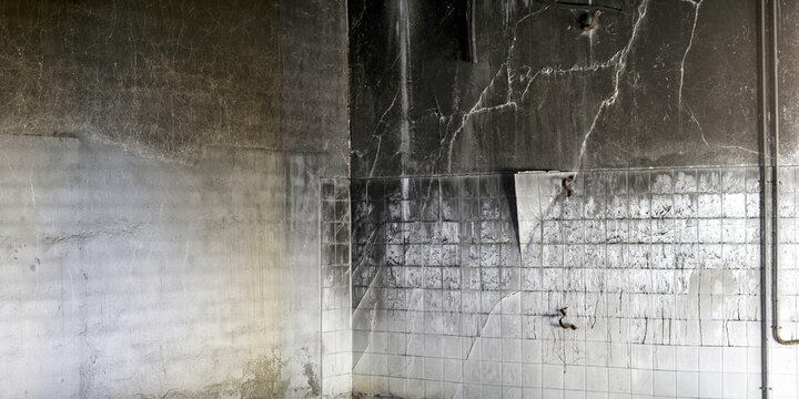 Shabby tiled wall with black stains