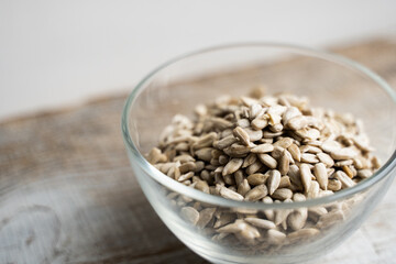 Sunflower seeds in a small plate on the wooden vintage table. Healthy vegetarian protein nutritious food. Sunflower seed on rustic old wood.