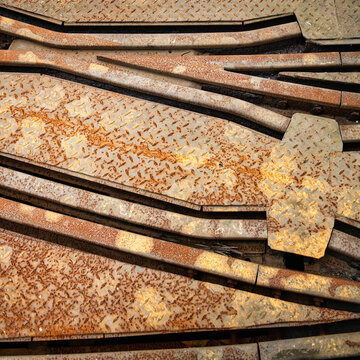 From above corroded rails covered with rust going through derelict industrial facility