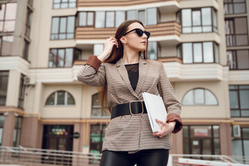 Beautiful young girl in a business suit on a background of business center. Business theme