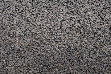 gray black granular asphalt road with small stones. rough surface texture