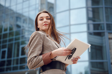 Beautiful young girl in a business suit on a background of business center. Business theme