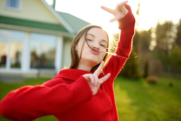 Cute preteen girl having fun outdoors on summer evening. Child exploring nature. Summer activities for kids.