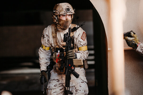 Soldier aiming airsoft gun during tactical game