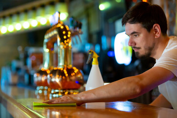 Young Bartender Cleaning the Bar
