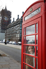 Fototapeta na wymiar Teenager Girl and Famous English red phone with Big Ben in London, UK
