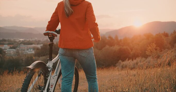 Woman in bicycle helmet with bike rides in country, Happy traveler girl biking in park on sunny summer day. Active healthy outdoor sport fun activity. Freedom, Travel, Journey.