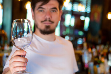 Young Bartender at the Bar with a Glass in his Hand