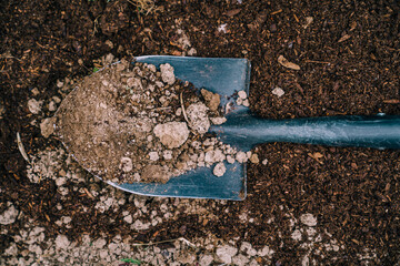 Shovel with soil in garden