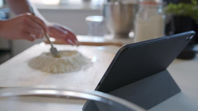 Out of Focus, Blurry Woman Mixing eggs into Flour, Making Dough at Home in a Kitchen. Slow Motion