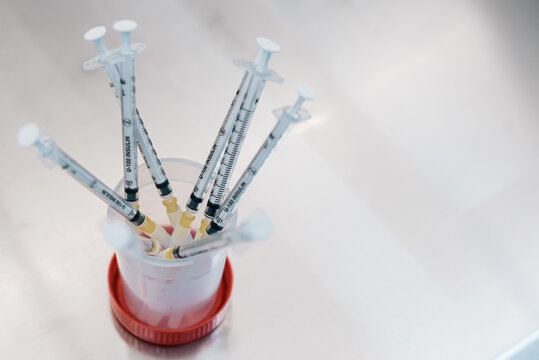 From above bunch of syringes with hormonal drugs placed in container on table in lab of fertility clinic