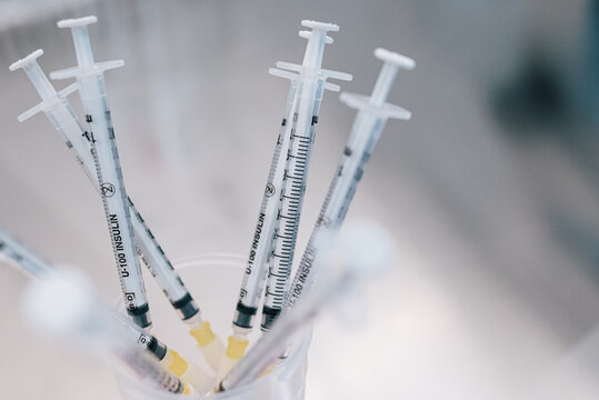 From above bunch of syringes with hormonal drugs placed in container on table in lab of fertility clinic