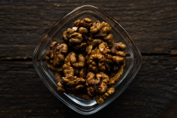 Walnut in a small plate on a vintage wooden table. Walnuts is a healthy vegetarian protein nutritious food. Natural nuts snacks.