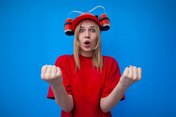 funny girl a fan in a red uniform and a beer hat watches the game and enjoy the victory, the winner screams and holds hands in fists