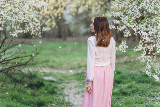 Amazing young woman posing in Blooming tree orchard at spring