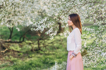 Amazing young woman posing in Blooming tree orchard at spring