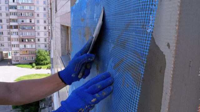 Industrial Climber using Trowel Putty Glue on Fiberglass Mesh to Insulate Facade