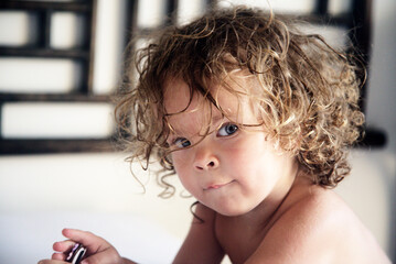 Portreat of a beautiful 2 years curly girl.