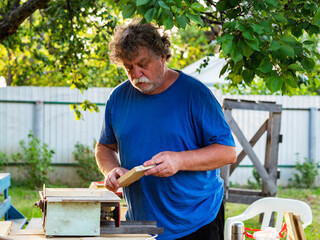 Carpenter using circular saw for cutting wooden plank