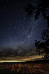 Milkyway rising over a mountain ridge with clouds on the horizon  