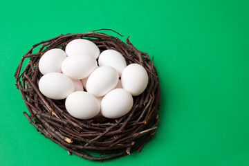 Bird nest with eggs isolated on green box background, top view, for copy space and product placement.