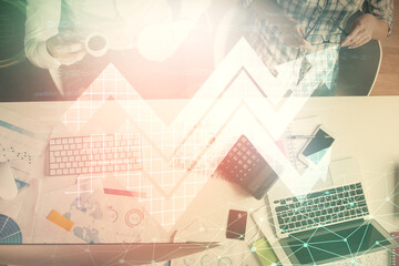 Fototapeta premium Double exposure of man and woman working together and arrows drawing. Computer background. Top View. Growth concept.