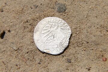 Fototapeta na wymiar antique silver european coin on the sand