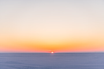 Fototapeta na wymiar Snow-covered surface of Baikal Lake on the sunset