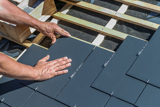 Craftsmen are installing a slate roof home.Professional roof workers repairing roof t.Working on rooftop.